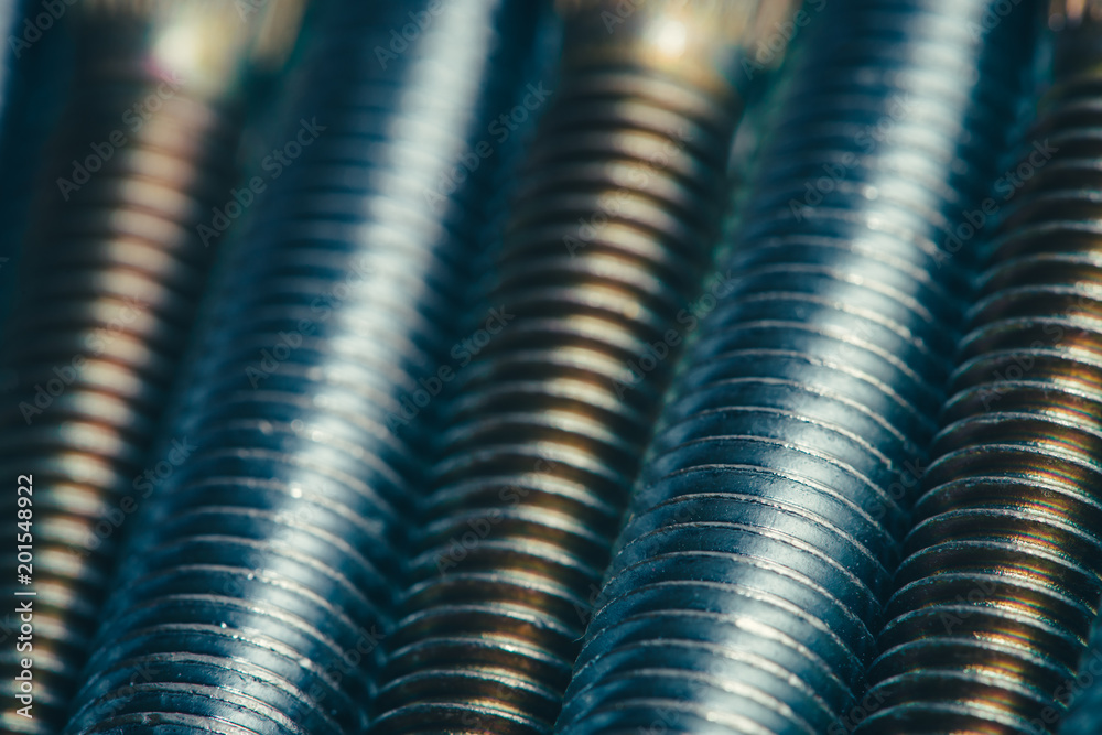 Background from automotive bolts in blue and yellow tones close up. Background from automotive bolts in blue and yellow tones close up.