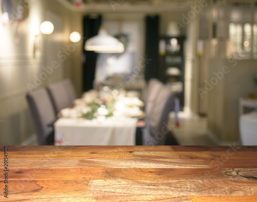 Empty wooden display table top front with blurred dining room on background
