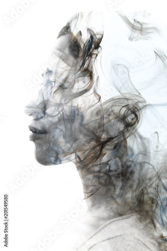 Double exposure profile portrait of a young sexy woman with pouty lips and a smoky texture dissolving into her facial features and hair