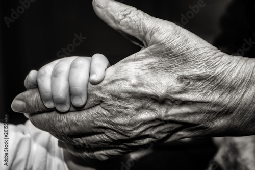 Childs hand and old wrinkled skin palm finger