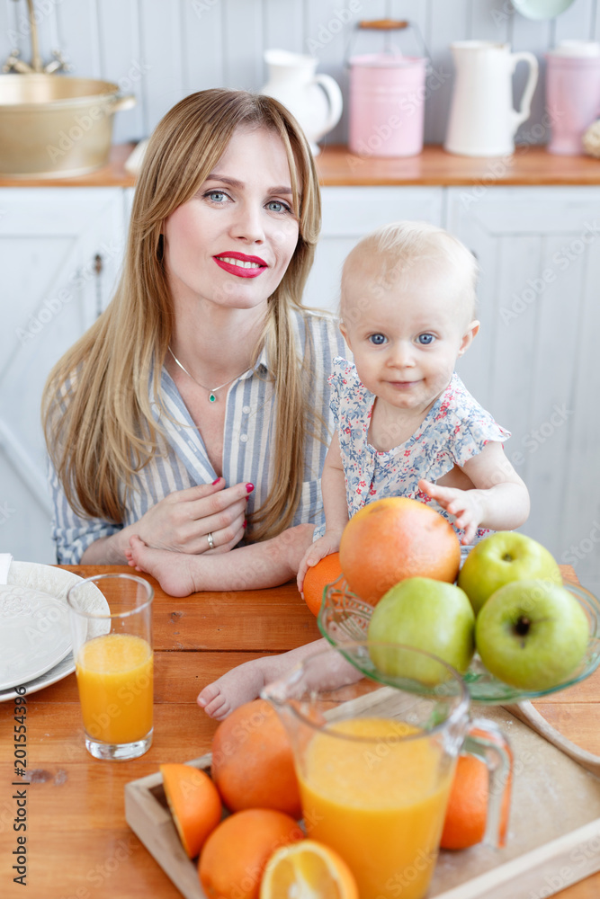 happy young family have lunch time with fresh fruits and vegetable food in bright kitchen. Funny girl with mom on kitchen. happy young family have lunch time with fresh fruits and vegetable food in bright kitchen. Funny girl with mom on kitchen.