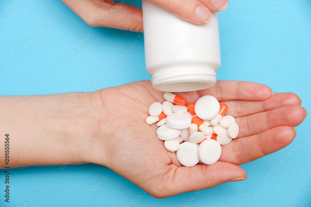The girl pours a lot of various tablets, vitamins, antibiotics, The girl pours a lot of various tablets, vitamins, antibiotics,