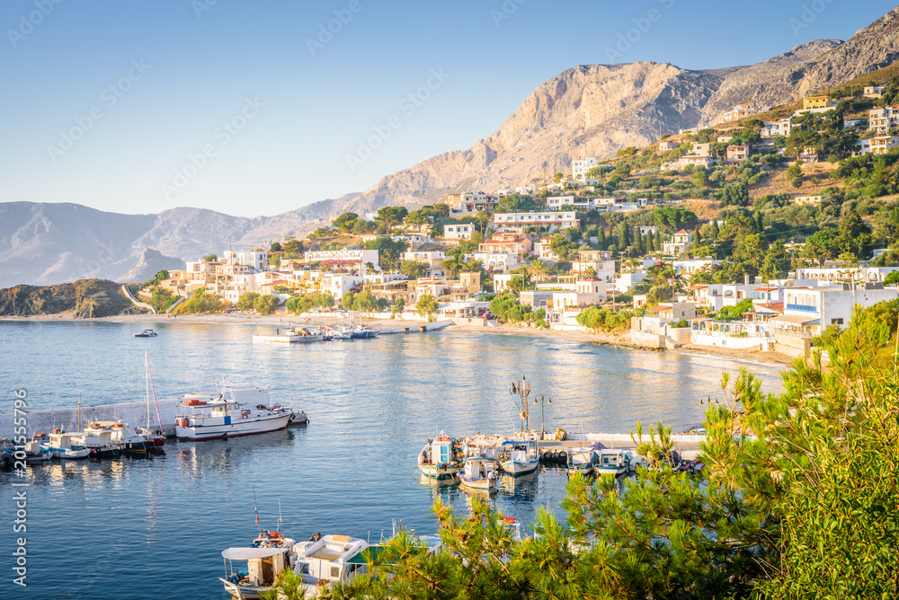Kalymnos Island, Massouri, Kos, Dodecanese, Greece: Beautiful sunny village town harbor view to the greek blue sea with crystal clear water with fishing boats cruising holiday yacht laying on shore