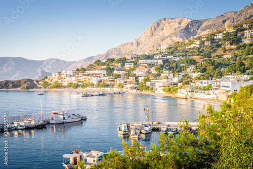 Obraz na płótnie Kalymnos Island, Massouri, Kos, Dodecanese, Greece: Beautiful sunny village town harbor view to the greek blue sea with crystal clear water with fishing boats cruising holiday yacht laying on shore w salonie