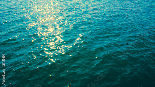 Black sea texture. Turquoise sea water with sun glare and ripple. Powerful and peaceful nature concept.