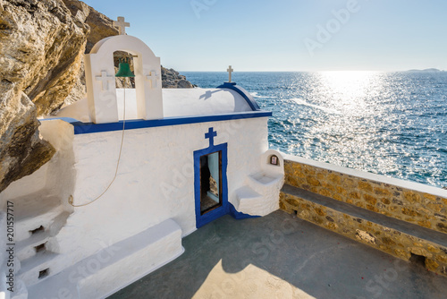Beautiful blue white greek church called Agios Georgios situated at the cliffs reachable by steps and views to the mediterranean sea and the stormy bay on Telendos Island, Kalymnos, Dodecanese, Greece photo