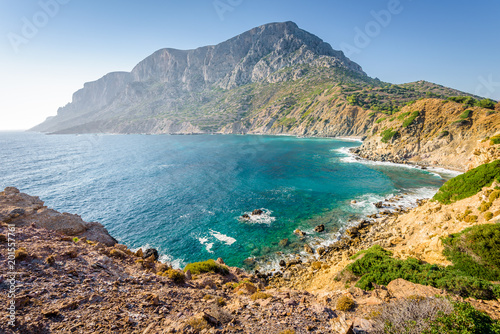 Obraz na płótnie Beautiful blue white greek church called Agios Georgios situated at the cliffs reachable by steps and views to the mediterranean sea and the stormy bay on Telendos Island, Kalymnos, Dodecanese, Greece w salonie