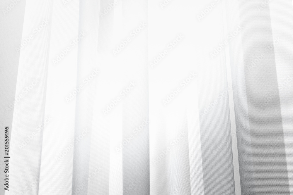 White wave of illuminated soft and gentle colored curtain made of lightweight fabric.