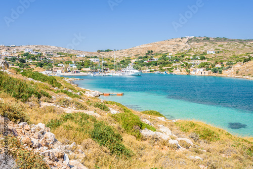 Fototapeta Naklejka Na Ścianę i Meble -  Beautiful sunny coast view to a small greek village harbor white houses with crystal clear blue water beach cruising fishing some boats and hills background, Arki Island, Leros, Dodecanese, Greece