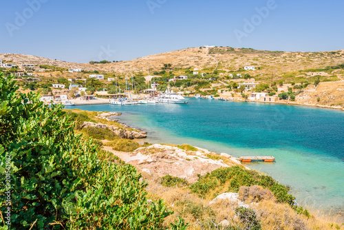 Fototapeta Naklejka Na Ścianę i Meble -  Beautiful sunny coast view to a small greek village harbor white houses with crystal clear blue water beach cruising fishing some boats and hills background, Arki Island, Leros, Dodecanese, Greece