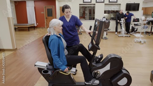 Medium shot of a senior woman using a rehabilitation bicycle photo