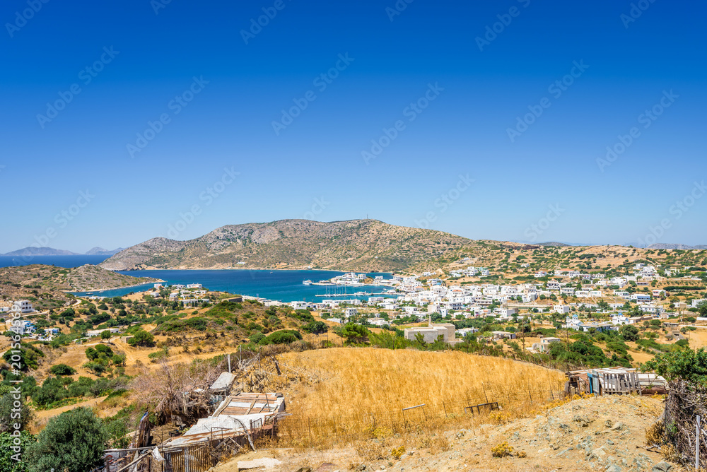 Beautiful sunny village town view with greek white blue church houses and aegean sea with crystal clear water fishing boats cruising yacht laying at harbour, Lipsi Island, Patmos, Dodecanese, Greece