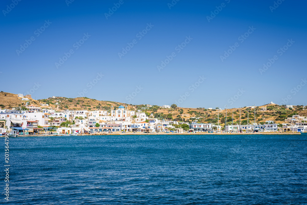 Lipsi, Patmos Island, Dodecanese, Greece: Beautiful sunny coast view to a cozy holiday bay with crystal clear blue water sandy beach for sunbathing and some boats cruising fishing