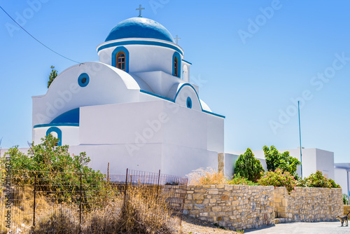 Фотография Beautiful white blue greek church situated in the streets of Lipsi at the medite