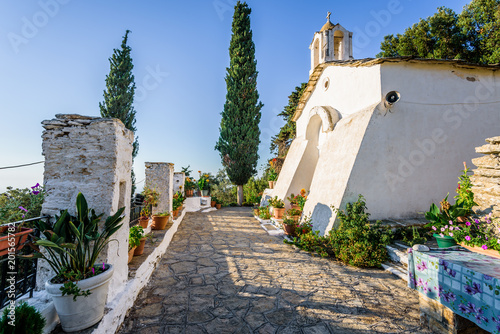 Obraz na płótnie Holy old ancient greek white stone Monastery church called Theoktistis shining over island at the mediterranean sea sourrounded by beautiful landscape and hidden by rocks in moutains, Ikaria, Greece w salonie