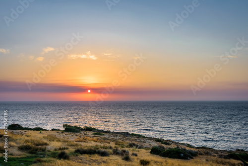 Beautiful colorful purple sunset sunrise coast view to a small greek town village with harbour fishing boats blue sea with crystal clear water, Ikaria Island, Armenisits, Sporades/ Greece - 08 05 2017