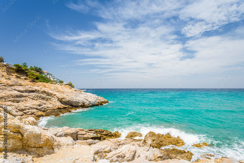 Beautiful sunny coast view to cozy holiday bay with crystal clear blue water sandy beach for sunbathing and heavy huge waves surfing from the greek sea, Ikaria Island, Armenistis, Greece - 08 04 2017