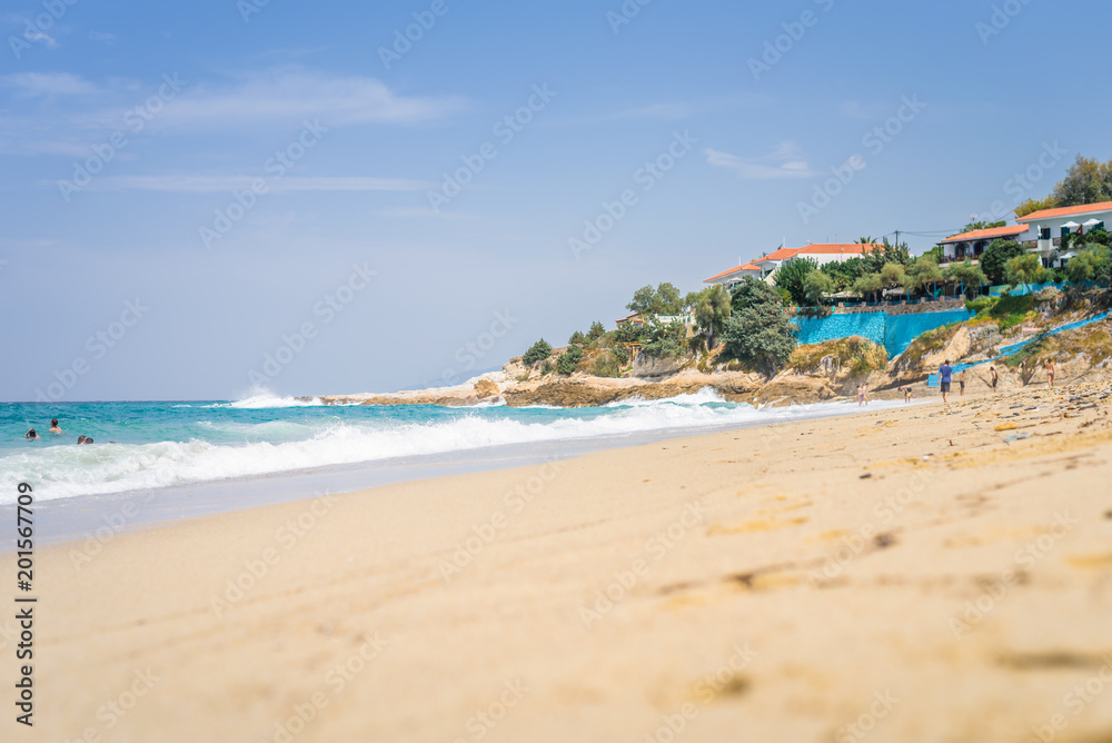 Beautiful sunny coast view to cozy holiday bay with crystal clear blue water sandy beach for sunbathing and heavy huge waves surfing from the greek sea, Ikaria Island, Armenistis, Greece - 08 04 2017