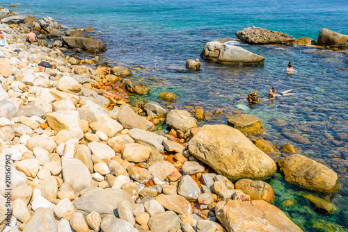 Beautiful sunny summer coast view to the greek blue sea crystal clear healthy water at a thermal hot spring shore beach healthy swimming, Agios Kirykos, Thermal Springs, Ikaria, Sporades, Greece