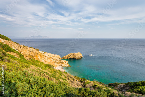 Fototapeta Naklejka Na Ścianę i Meble -  Beautiful sunny summer coast view to the greek blue sea with crystal clear water relaxing holiday beach perfect for sunbath at the shore with a small rock, Agios Kirykos, Ikaria, Sporades, Greece 