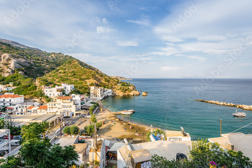 Fototapeta Naklejka Na Ścianę i Meble -  Beautiful sunny summer coast view to the greek blue sea with crystal clear water relaxing holiday beach perfect for sunbath at the shore or eating restaurant dinner, Therma, Ikaria, Sporades, Greece 
