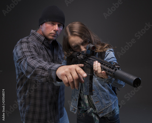 Father teaching his teenage daughter how to shoot a rifle to defend herself. Doomsday Preparedness.