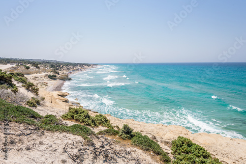 Fototapeta Naklejka Na Ścianę i Meble -  Beautiful sunny coast view to greek beach mediterranean blue sea with crystal clear water and pure white sand empty place with some mountains rocks, Theologos, Kefalos, Kos, Dodecanese Islands, Greece