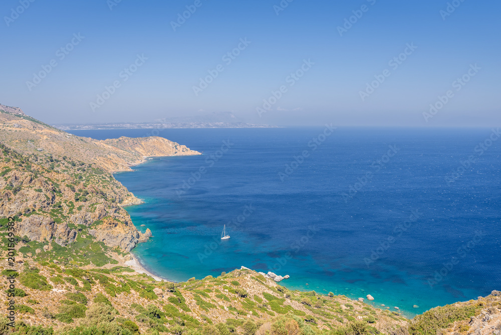 Beautiful sunny coast view to the greek mediterranean blue sea with crystal clear water and pure sandy beach empty place with some mountains rocks surrounded, Kos, Dodecanese Islands, Greece