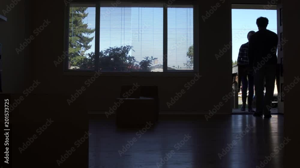 Couple carrying table through doorway of new home. Couple carrying table through doorway of new home.