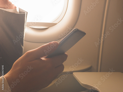 Man using smartphone in the airplane.