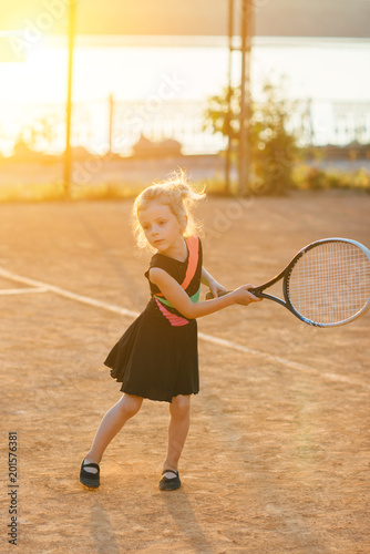 Little cute girl playing tennis