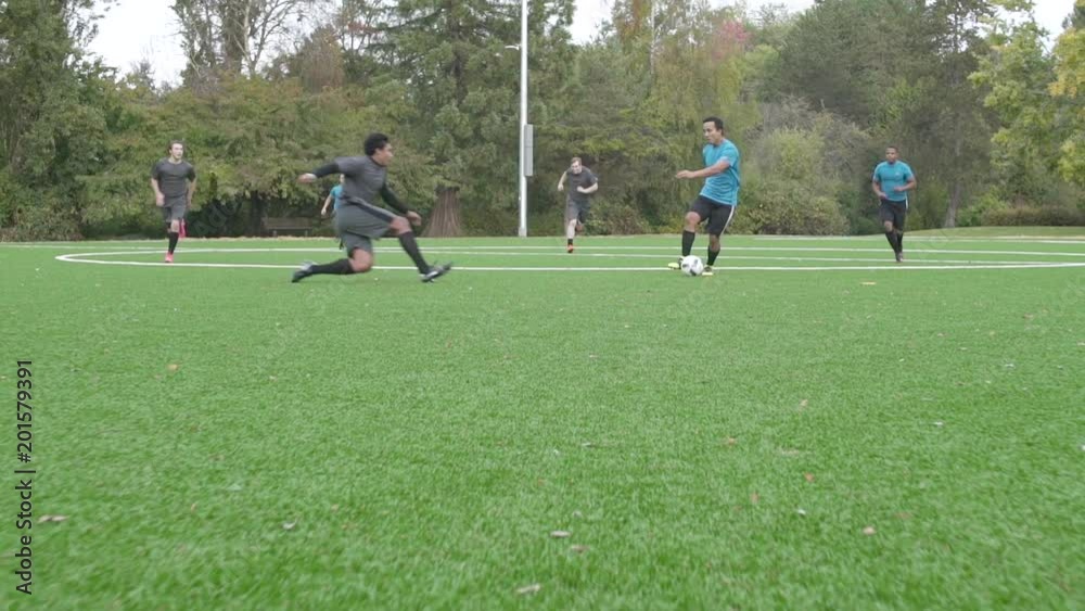 Male soccer players playing soccer with one man injuring himself. Male soccer players playing soccer with one man injuring himself.