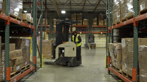Two workers using forklifts in a warehouse