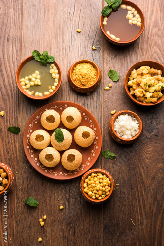 Pani Puri is Indian chat item served in a terracotta bowls and plate
