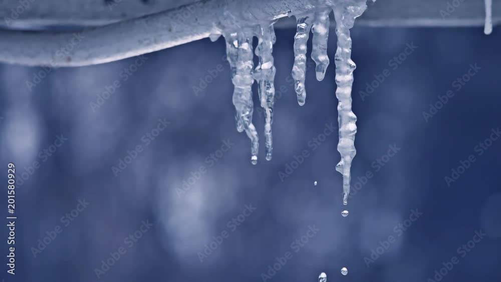 Melting icicle and drop of water close up. winter is the end water drips from icicles outdoors Melting icicle and drop of water close up. winter is the end water drips from icicles outdoors