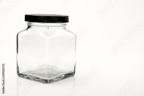Square empty glass jar with black lid.