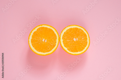 Orange cut in half on a pink background