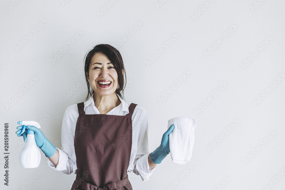 掃除道具を持っている笑顔の主婦