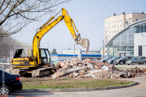 Crawler excavator is working on construction site. The excavator unloads construction debris_
