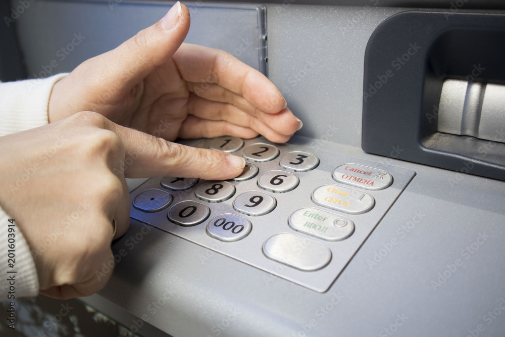 girl's hand dials the password in the ATM, selective focus. girl's hand dials the password in the ATM, selective focus.