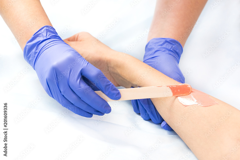 The process of classical wax depilation of female limbs in the beauty salon. The process of classical wax depilation of female limbs in the beauty salon.