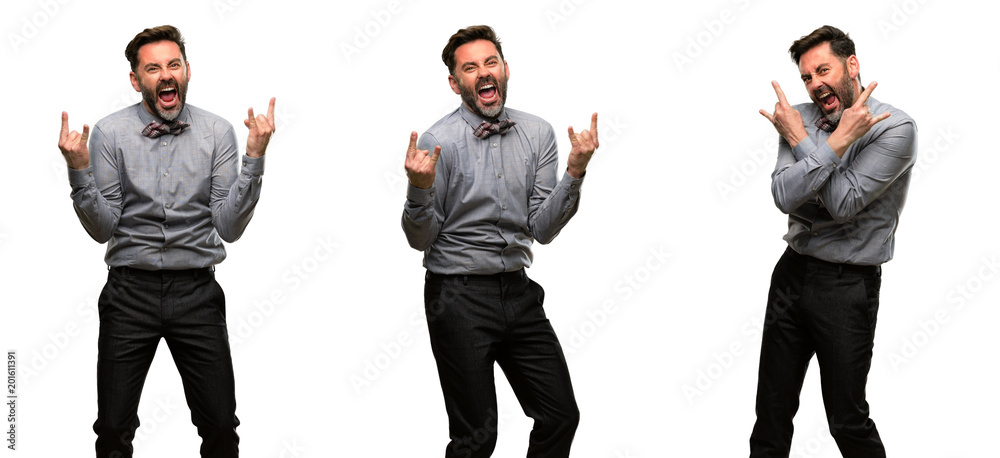 Middle age man, with beard and bow tie making rock symbol with hands, shouting and celebrating Middle age man, with beard and bow tie making rock symbol with hands, shouting and celebrating