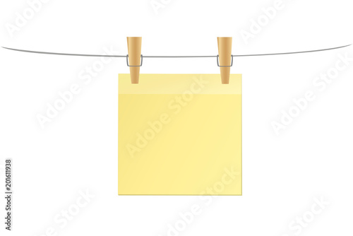 Wooden pins for clothes hang on a rope and hold a yellow sheet 