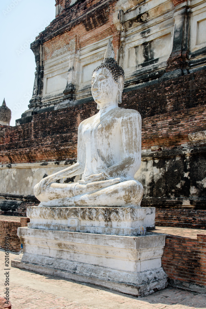Obraz premium Mausoleum Historical and buddha statues remain in Phra Nakhon Si Ayutthaya, at Wat Yai Chai Mongkol Thailand, one of the famous historical landmark in the center of Thailand.