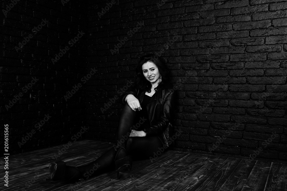Studio portrait of sexy brunette girl in black leather jacket against brick wall. Studio portrait of sexy brunette girl in black leather jacket against brick wall.