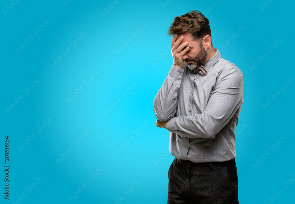 Middle age man, with beard and bow tie stressful keeping hands on head, tired and frustrated Middle age man, with beard and bow tie stressful keeping hands on head, tired and frustrated