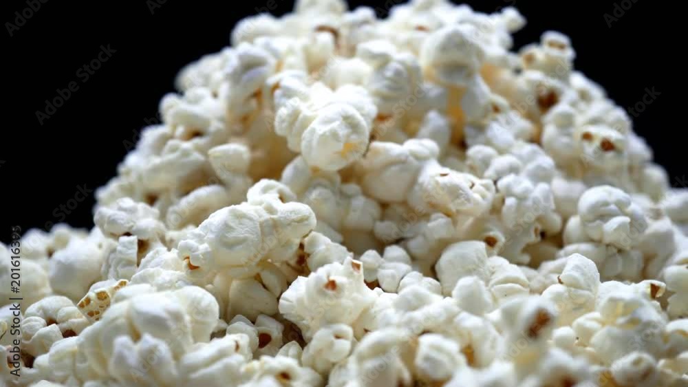 Fluffy popcorn macro, airy popped corn snack served at cinema, entertainment. On a rotating wooden table. 4K Fluffy popcorn macro, airy popped corn snack served at cinema, entertainment. On a rotating wooden table. 4K