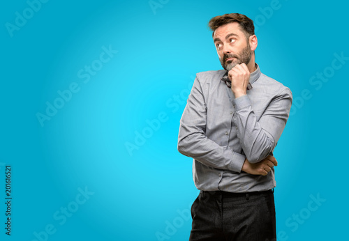 Middle age man, with beard and bow tie thinking and looking up expressing doubt and wonder