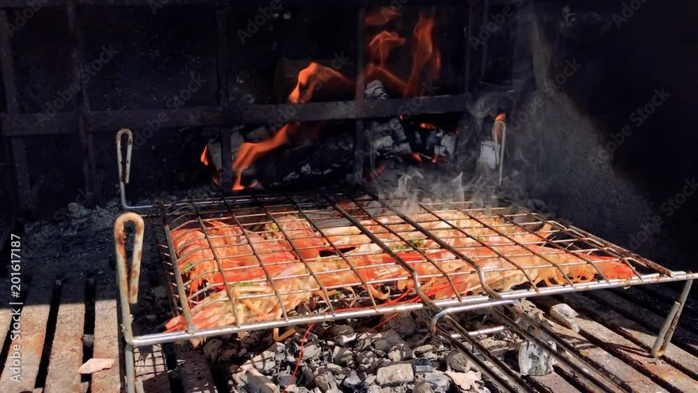 Grilled fish in the barbecue with fire during a sunny day Grilled fish in the barbecue with fire during a sunny day