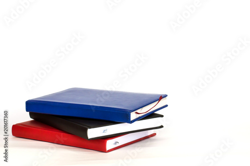 three notebook are stacked on each other on white background